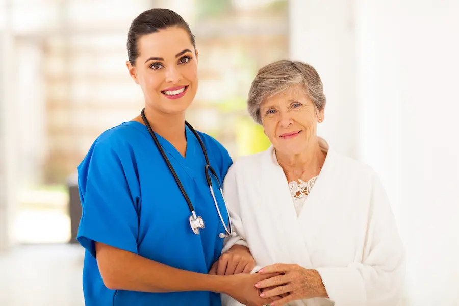 senior woman and caring young nurse